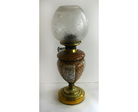A late 19th Century oil lamp With ceramic body removable glass font and circular brass loaded base, bears marks for Evered & 