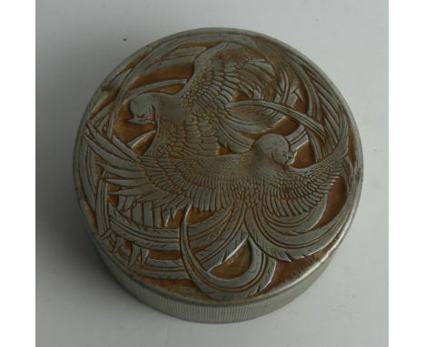 A Roger et Gallet Aluminum Powder Compact
Lalique Design, circa 1920's embossed decoration with birds of paradise, diameter 7