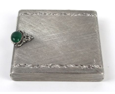 An 800 grade silver compact
Having engine turned decoration with two lines of floral motifs and green Chalcedony clasp, circa
