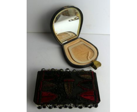 A vintage Art Deco style powder compact
Of rectangular form, having applied jeweled and black jet style beads with material, 