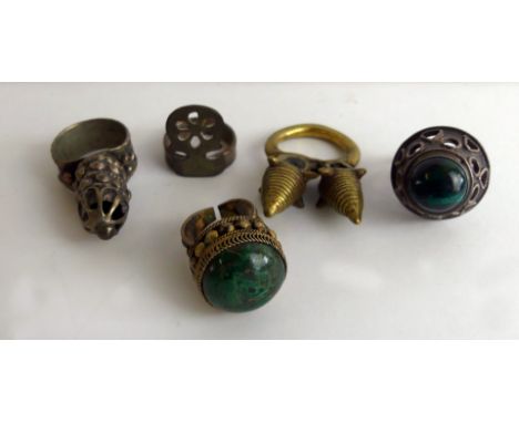 A collection of five brass and white metal ringsTo include a yellow metal and a white metal example with green stones, white 
