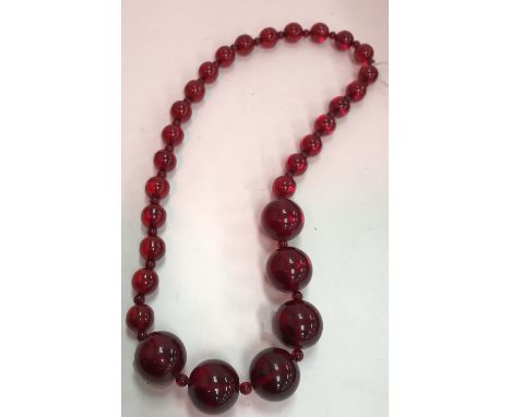 A vintage cherry amber graduated bead necklace, largest beads approx 1.5 cm diameter, 62 cm long overall, total weight 110 g 