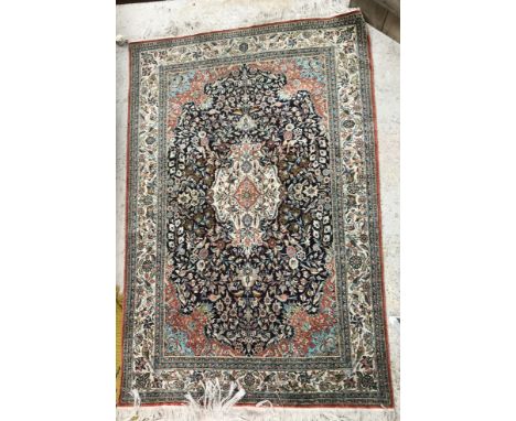 A Persian silk rug, the central panel set with foliate decorated medallion on a dark blue and salmon foliate and bird decorat