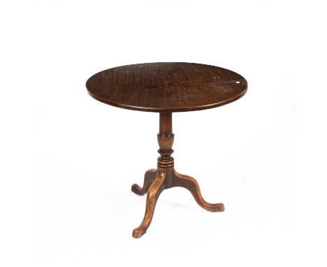 A Provincial George III mahogany tilt-top tripod table, the circular top above a baluster turned column and downswept legs te