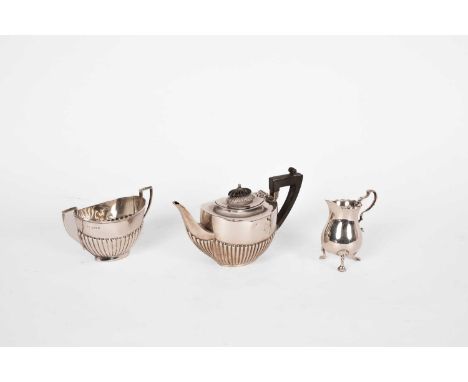 A bachelor's silver teapot and sugar basin, Birmingham 1912, of oval half-gadrooned form and a small cream jug, Mappin &amp; 