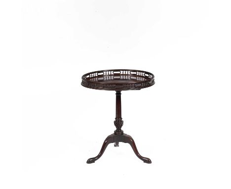 A George II mahogany tripod table, the circular top with balustrade gallery and handholds, upon a turned stem with spiral flu