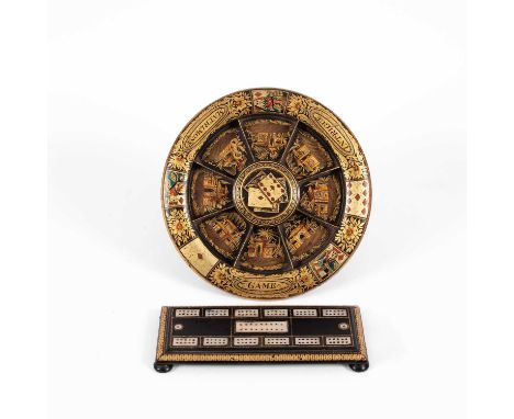 An early 19th Century black japanned Pope Joan board decorated in gilt with playing cards, flowers and anthemions, the centra