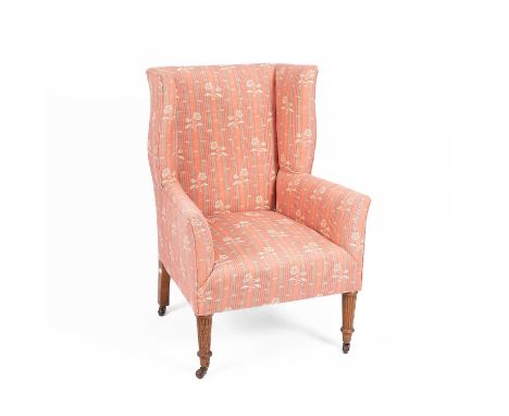 A late Victorian wingback armchair, of small proportions, on reeded tapering front legs with ceramic castors, 65cm wide, 92cm