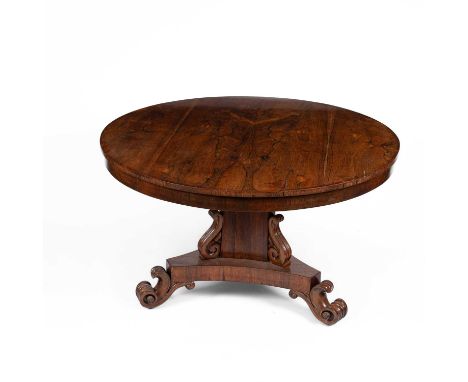 A Regency rosewood oval tilt-top breakfast table on a carved column support, on trefoil base with applied scroll feet, 122.5c