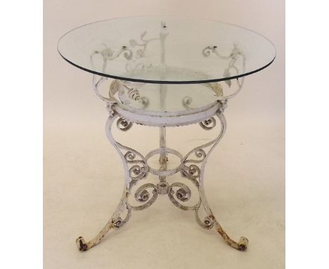 A vintage wrought iron glass topped circular garden table