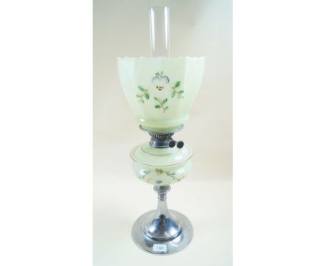 An early 20th century oil lamp with floral painted glass shade and reservoir