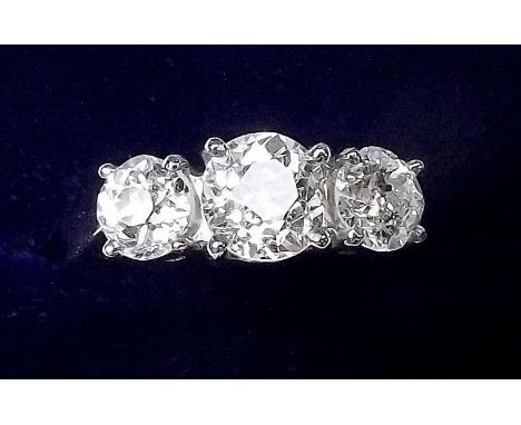 A fine platinum set three stone diamond ring - the centre stone 1.16 carats, flanked by two diamonds, 60pts each, size M