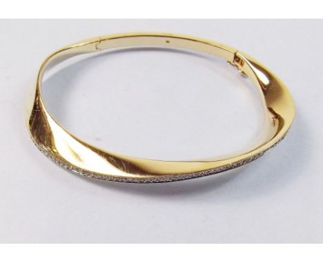 An 18ct gold hinged bangle set row of diamonds, 40g