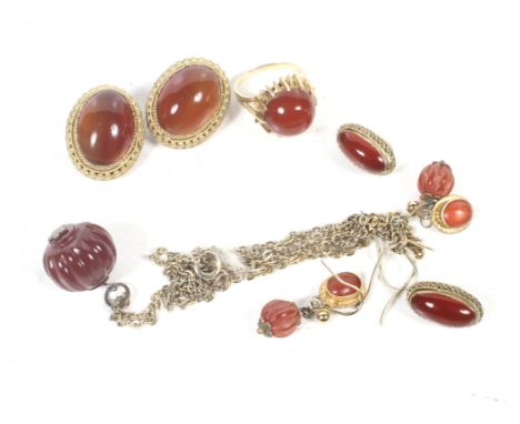 A collection of carnelian jewellery including a round cabochon single stone ring. The flat-section shank indistinctly stamped