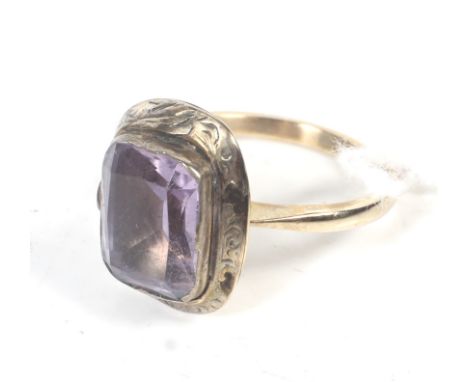 A vintage gold and pale amethyst single stone ring. The rectangular step-cut stone rub-over set on a D-section shank stamped 