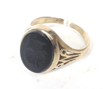 A 9ct gold and hematite intaglio signet ring. The oval hematite depicting a Roman centurion, rub-over set between tapering sh