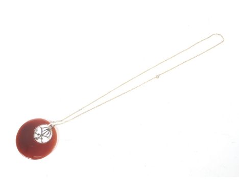 A Saudi Arabian gilt metal and carnelian pendant. The pendant curently hung from a yellow metal oval trace link necklace on a
