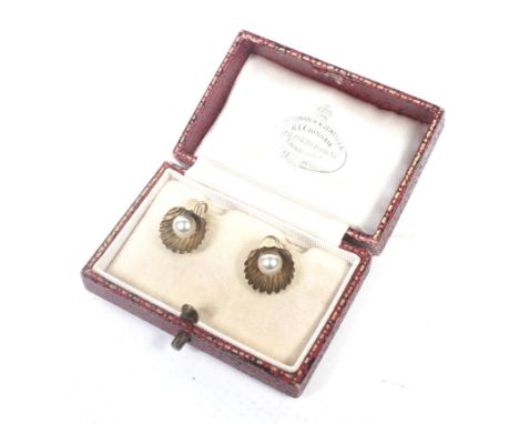 A pair of early 20th century gold and imitation-pearl shell-shaped earrings. On gold screw fittings stamped '9ct', 2.84g gros