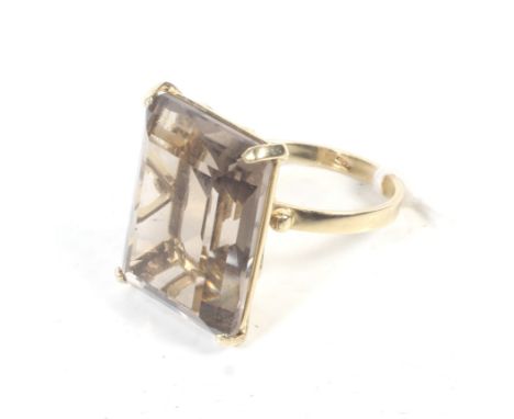 A vintage Italian gold and rectangular smokey quartz single stone ring. The large rectangular trap-cut stone, claw set on an 