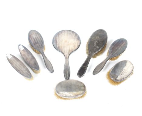 A silver five piece dressing table set and other brushes. The set comprising a round hand mirror, two oval hair brushes and t