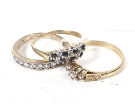 Three vintage 9ct gold and cubic zirconia rings. comprising; a graduated three stone ring, size N; a ten stone channel set ha