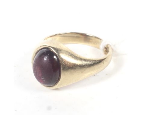 A vintage 9ct gold and garnet single stone ring. The oval cabochon garnet rub-over set between tapering shoulders on a D-sect