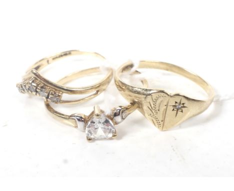 Three 9ct gold and cubic zirconia dress rings. In various designs including; a heart-shaped single stone ring, size N; a wish