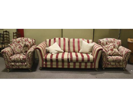 An Alston's Courtney contemporary upholstered three-piece suite. Including a three seater sofa and two armchairs on brass cas