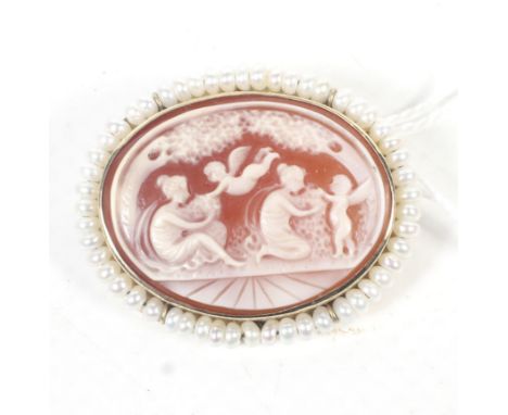A vintage gold, small fresh-water bouton pearl and oval shell cameo brooch depicting Venus attended by cupids. The frame indi