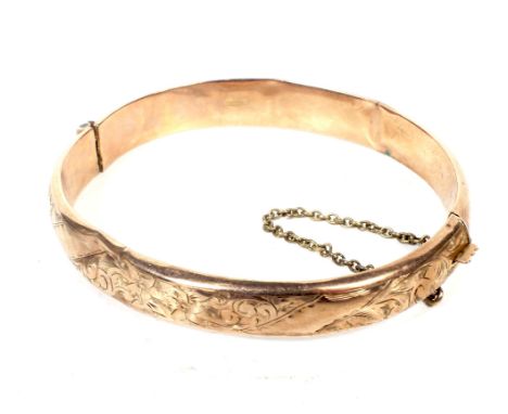An early 20th century 9ct rose gold hollow hinged bangle. The top engraved with foliate scrolls (many dents), hallmarks for C