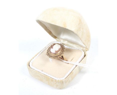 A modern 9ct gold and oval shell cameo ring. The cameo depicting an unknown female profile, rub-over set within a pierced pet