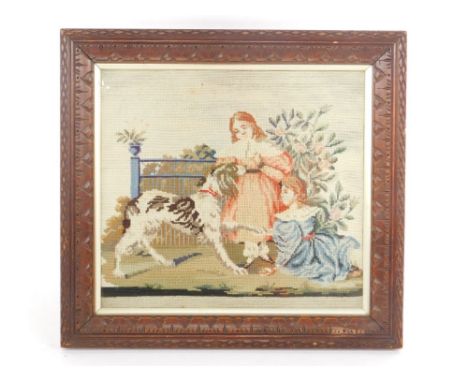 An early 19thC woolwork tapestry, depicting two girls in a garden with a hound, 23.5cm x 26.5cm.