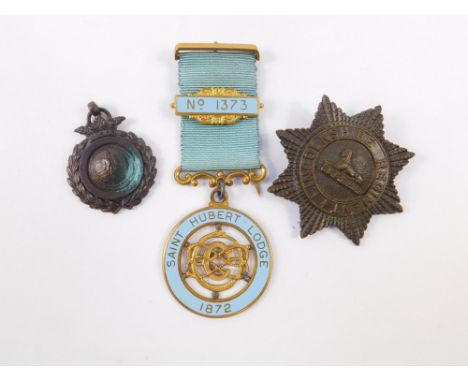 A St Hubert Lodge 1872 jewel, No 1373, Lincolnshire Regiment cap badge, and a bronze sporting medallion. (3)