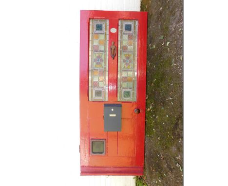 An Edwardian red painted front door, inset two stained glass floral panels, with cast iron door knocker, 198cm x 80.5cm.