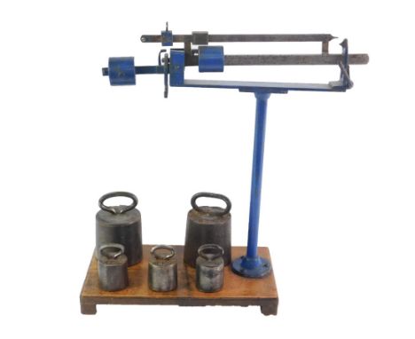 A set of German cast iron and steel scales, raised on a wooden base, with weights, 1Kg and 5Kg.