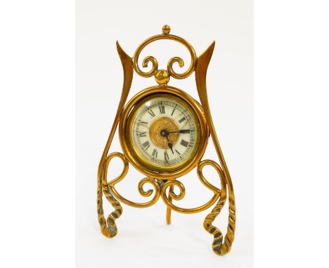 A Victorian brass strut bedside clock, circular brass dial with enamel chapter ring bearing Roman numerals, movement by The A