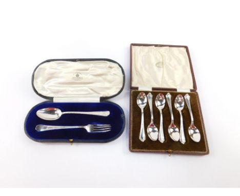 A set of six George V silver teaspoons, cased, Birmingham 1935, together with a George V silver fork and spoon set, monogram 
