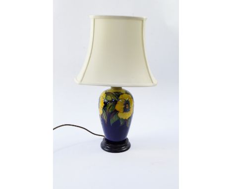 A Moorcroft Pottery table lamp decorated in the Golden Pansy pattern, against a blue ground with shade, 51cm high.