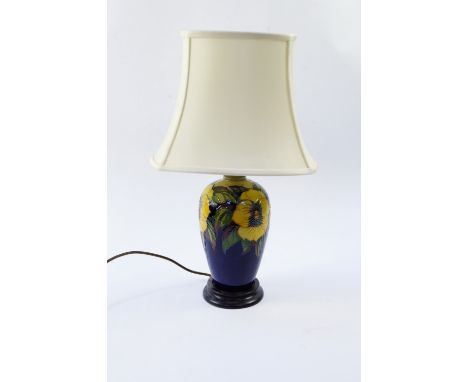 A Moorcroft Pottery table lamp decorated in the Golden Pansy pattern, against a blue ground with shade, 51cm high.