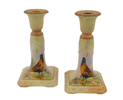 A pair of Locke & Company Ltd Worcester porcelain candlesticks, decorated with pheasants, by W Stinton, signed, 14cm high.