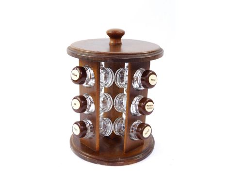 A Polish oak circular spice rack, containing twelve bottles with named plastic lids, 26cm high.