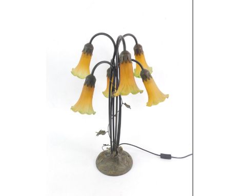 A Tiffany style cast metal and glass six branch table light, with six yellow to green glass shades, raised on a six branch st