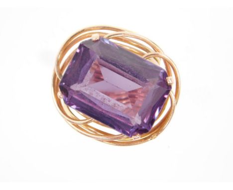 An Egyptian gold and amethyst ring, in an open and entwined double shank design, the emerald cut amethyst approx 15cts, size 
