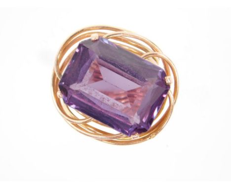 An Egyptian gold and amethyst ring, in an open and entwined double shank design, the emerald cut amethyst approx 15cts, size 