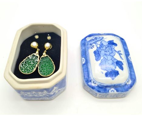 An intricately carved green jade pair of earrings with genuine pearls. Length: 6 cm. Presented in a Chinese, blue and white, 