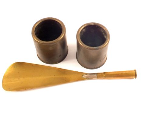 A pair of ejector seat cartridge cases with a Trench Art shoe horn made from a .303 round