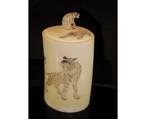 A 19th Century Japanese Meiji Period carved ivory pot and cover, the cover decorated with prowling tiger with seated tiger fi