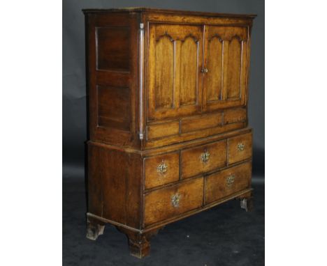 A 19th Century oak cupboard with Cavetto moulded cornice above two panelled doors enclosing a shelf, raised on a base of thre