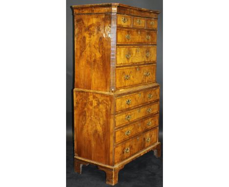 An early 18th Century walnut and feather-banded chest on chest, the upper section with moulded cornice over three short and t
