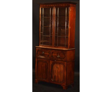 A late Regency mahogany secrétaire bookcase, the upper section with beaded and moulded cornice above two glazed and ebony str
